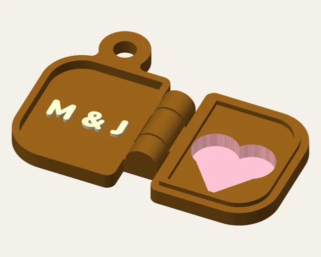 Brown hinged locket keychain shown open: initials M & J inside one half, a pink translucent heart window in the lid.