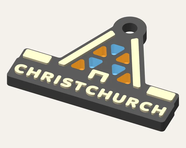 Dark grey keychain filled by a tall A-frame cathedral with cream tubes and translucent orange and blue window panes, above the word CHRISTCHURCH.